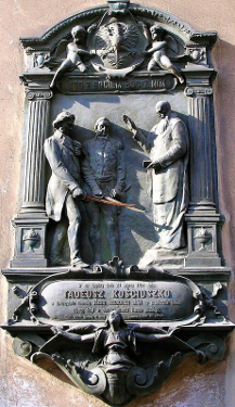 Fotografia: Pamiątkowa tablica z płaskorzeźbą Święcenie pałaszy, dzieło Alfreda Dauna z 1896, wmurowana w zewnętrzną ścianę Domku Loretańskiego &ndash; kaplicy po p&oacute;łnocnej stronie Kościoła Kapucyn&oacute;w, gdzie podczas mszy św. 24 marca 1794 generałowie Tadeusz Kościuszko i J&oacute;zef Wodzicki złożyli ślubowanie i otrzymali poświęcone szable.